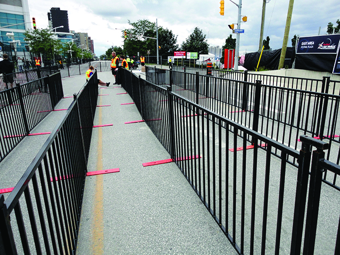 La clôture noire à piquets de Modu-Loc est utilisée pour créer des files d'attente lors d'un événement en plein air.